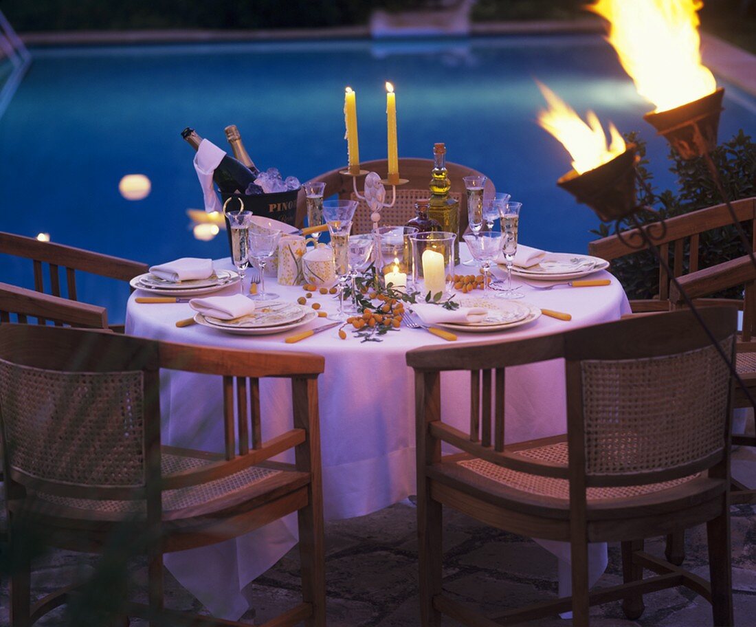 Festlich gedeckter Tisch am Pool; Abendstimmung