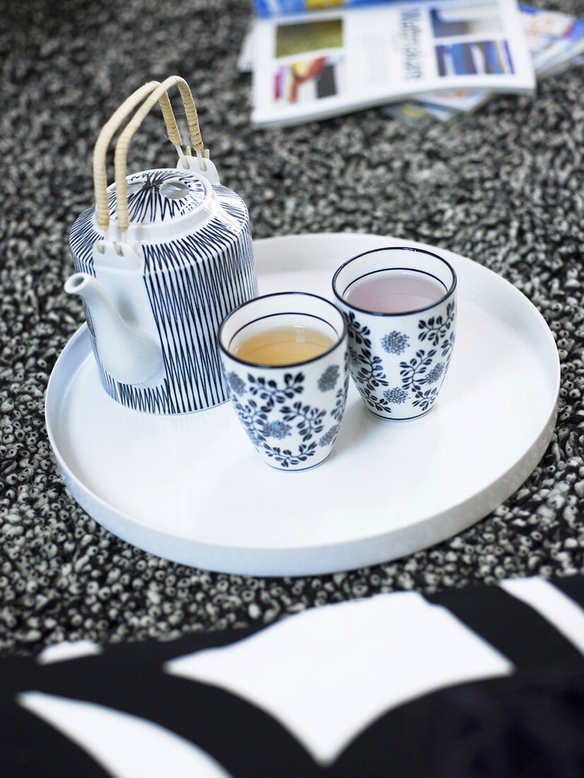 Two beakers of tea and teapot on a tray