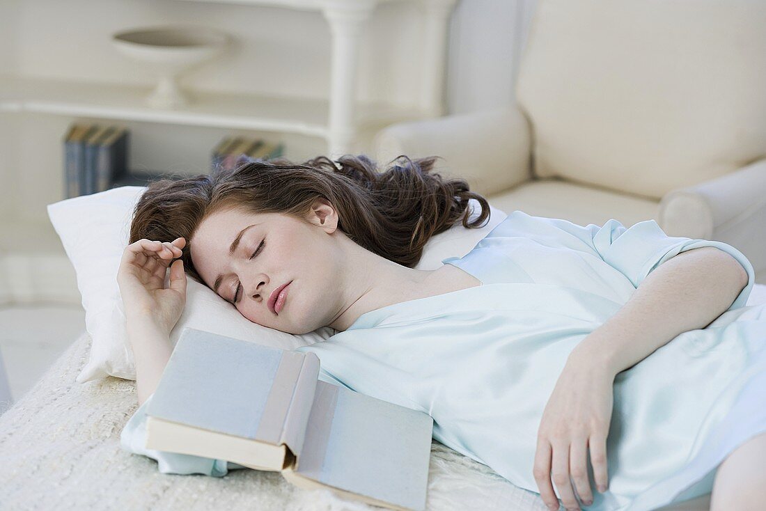 Frau schläft mit Buch
