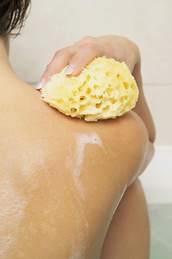 A woman washing with sponge