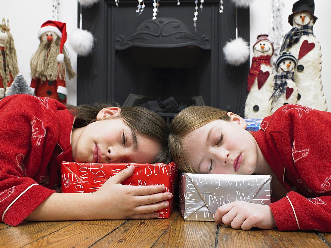 Kinder schlafen auf ihren Geschenken