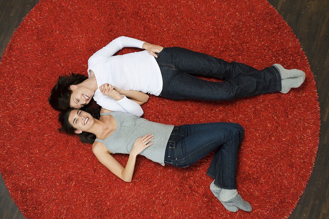 Frauen liegen auf Teppich