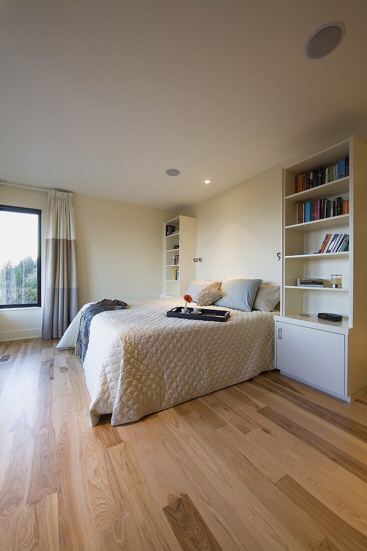 Schlafzimmer mit Doppelbett, Parkettboden & Wandregalen