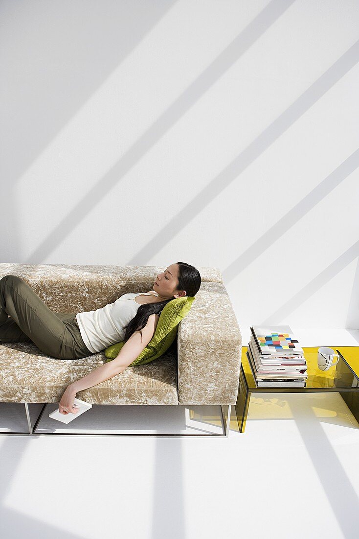 Frau relaxed auf Sofa in modernem Wohnzimmer