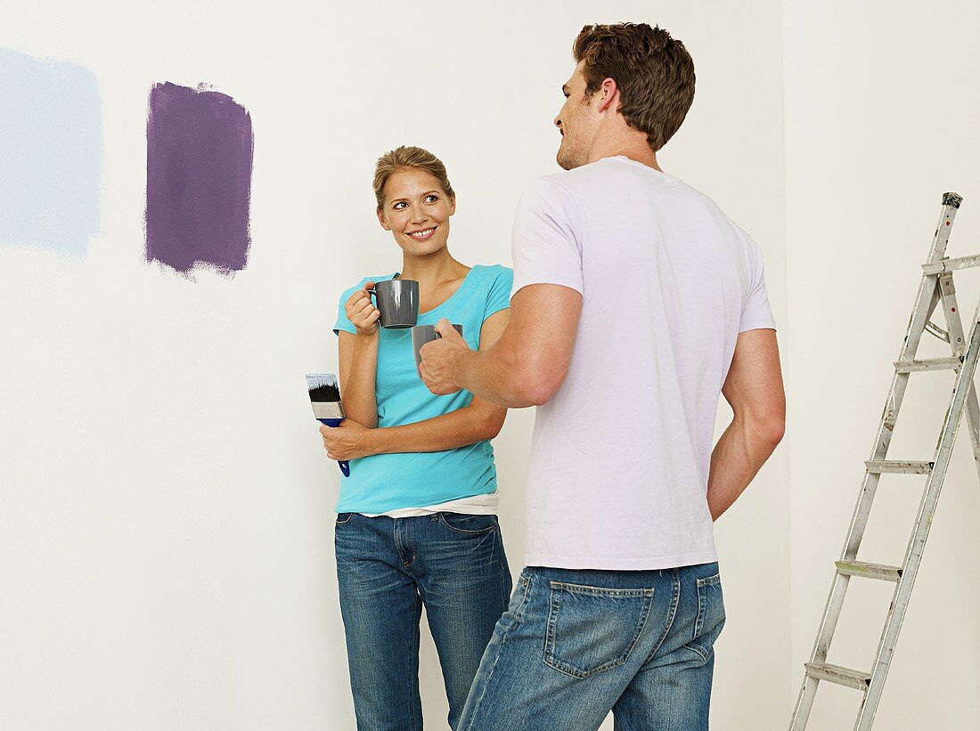 A young couple choosing paint for a wall