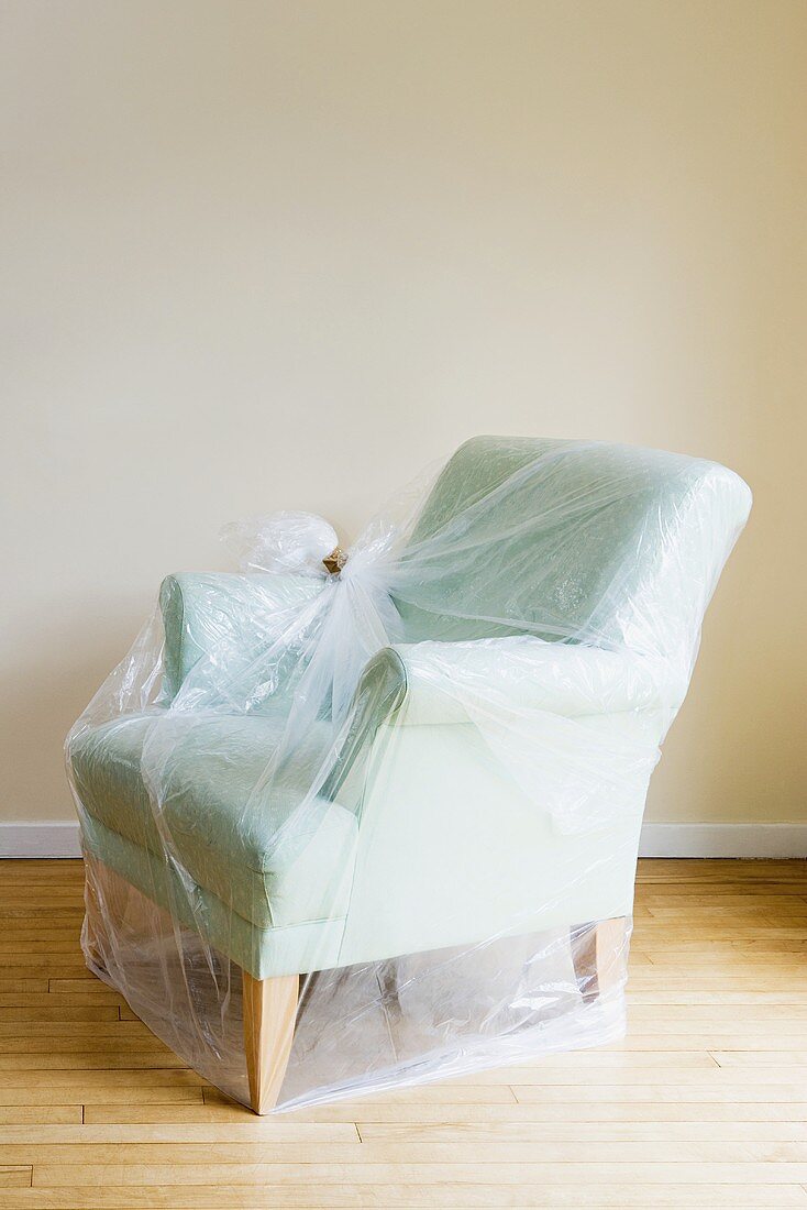 An armchair protected by plastic