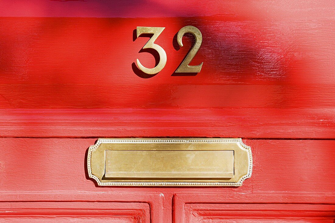 Rote Haustür mit Hausnummer und Briefschlitz