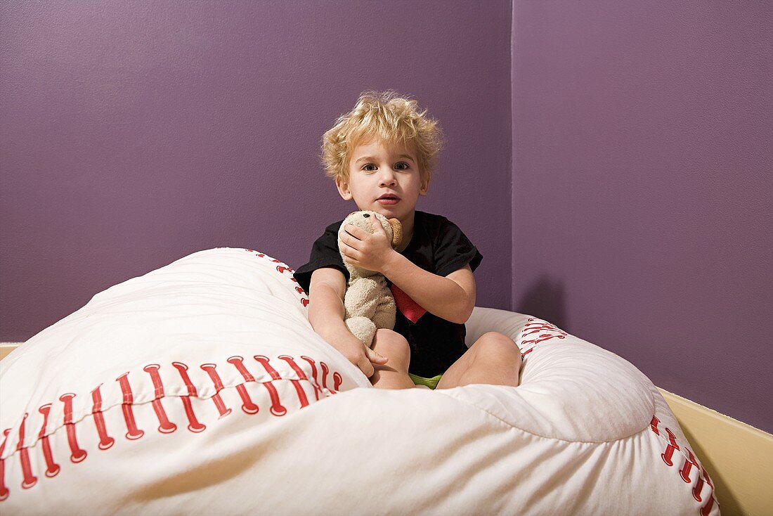 Boy in bed with teddy bear