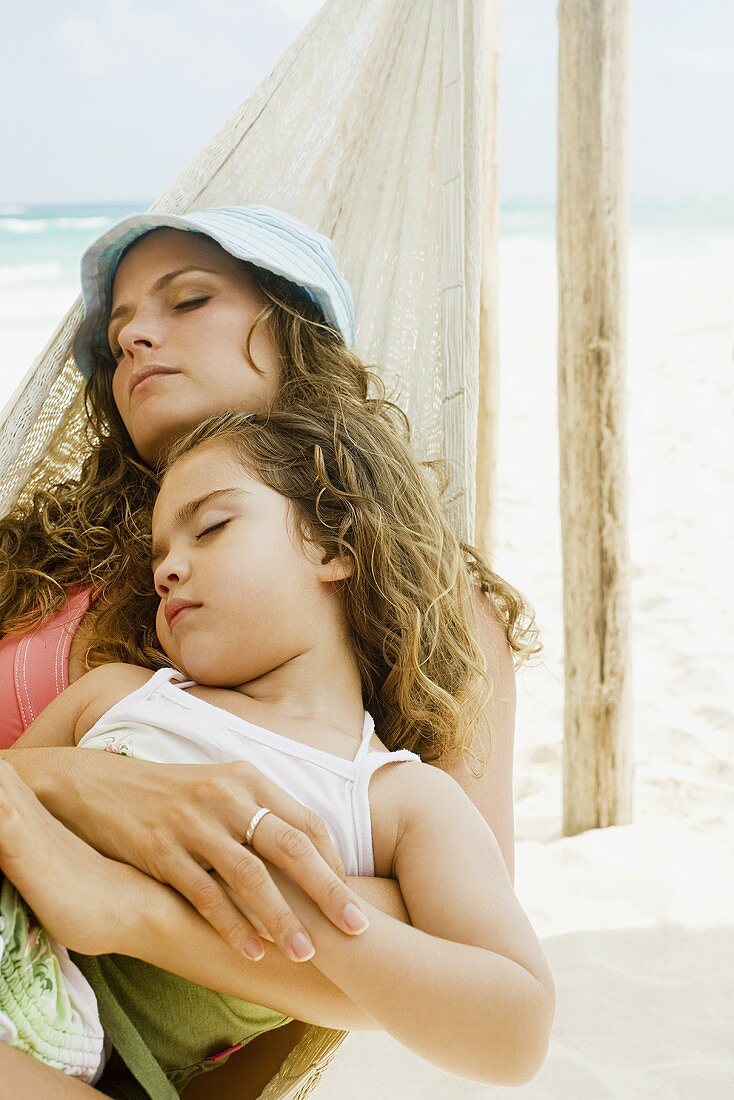 A mother and daughter sleeping on a hammock