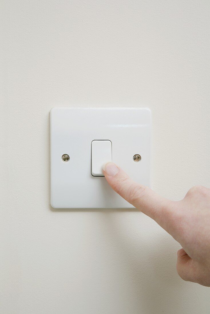 A finger on a light switch