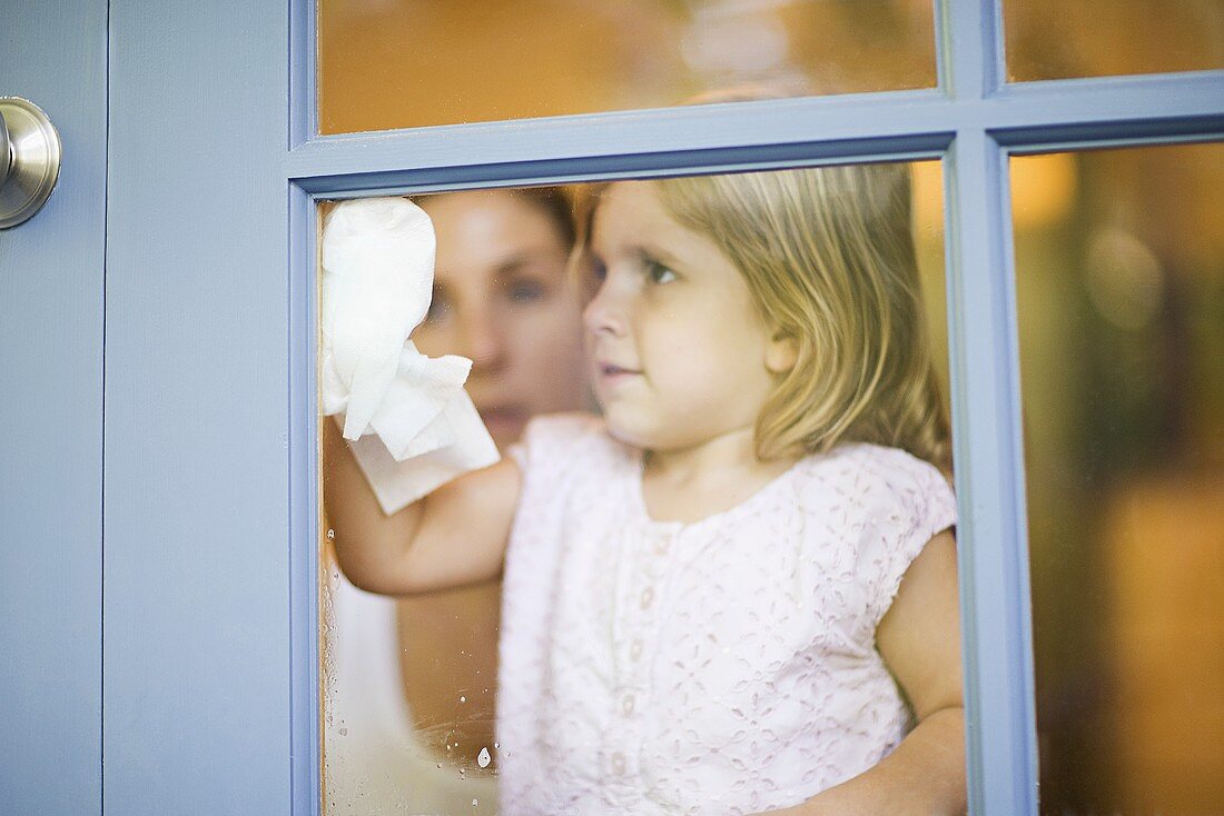 Mädchen putzt Fenster