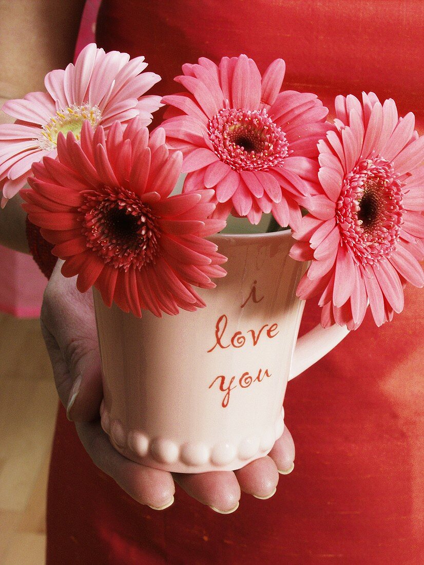 Hand hält I love you Tasse mit Blumen