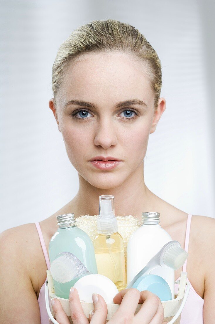 Young woman holding a basket of cosmetics