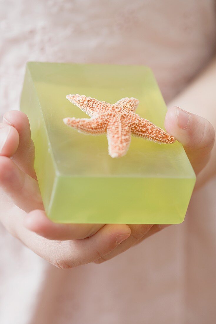 Girl holding green soap with starfish
