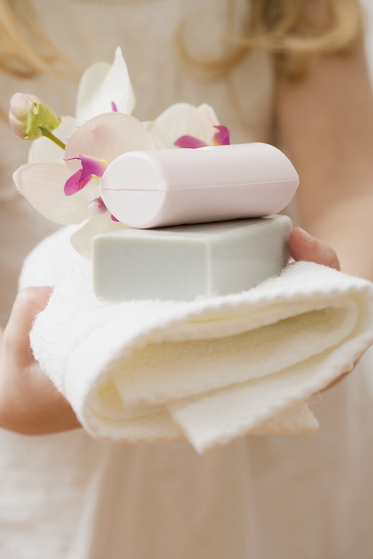 Girl holding soaps and towel