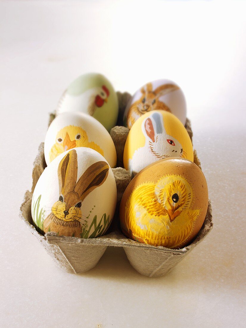 Mit Tiermotiven bemalte Ostereier im Eierkarton