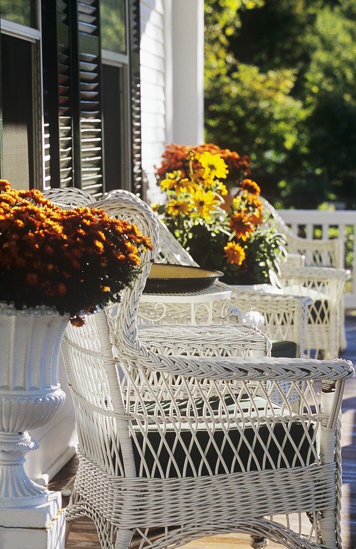 Veranda mit Stühlen, Tisch und Blumen in Neuengland