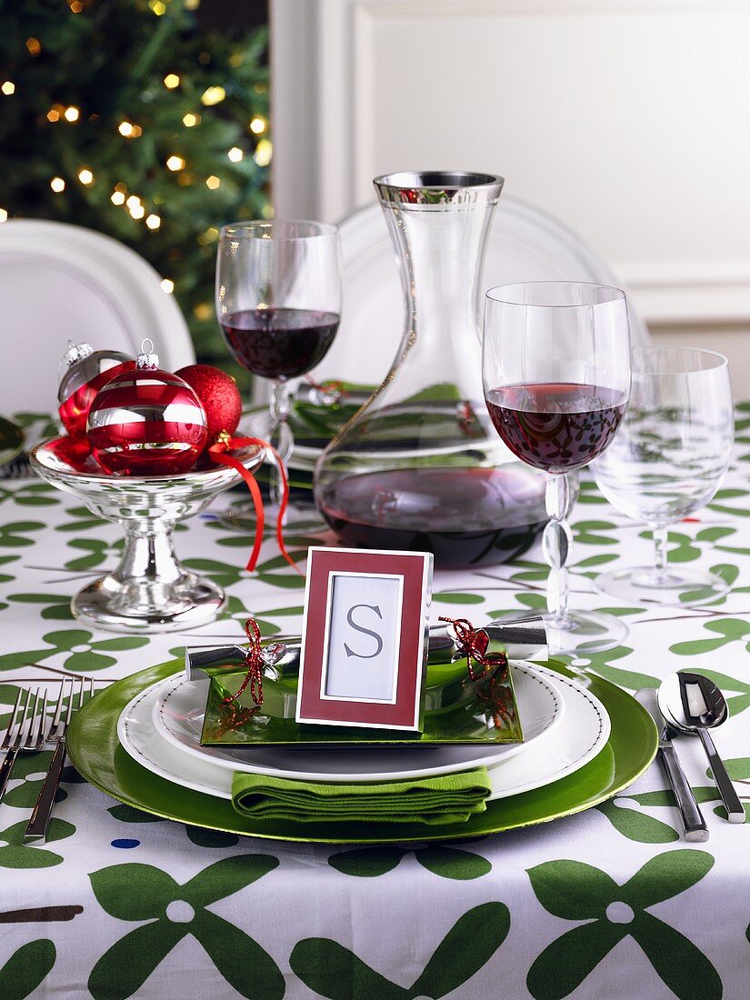 Grün-weiss gedeckter Weihnachtstisch mit Rotwein