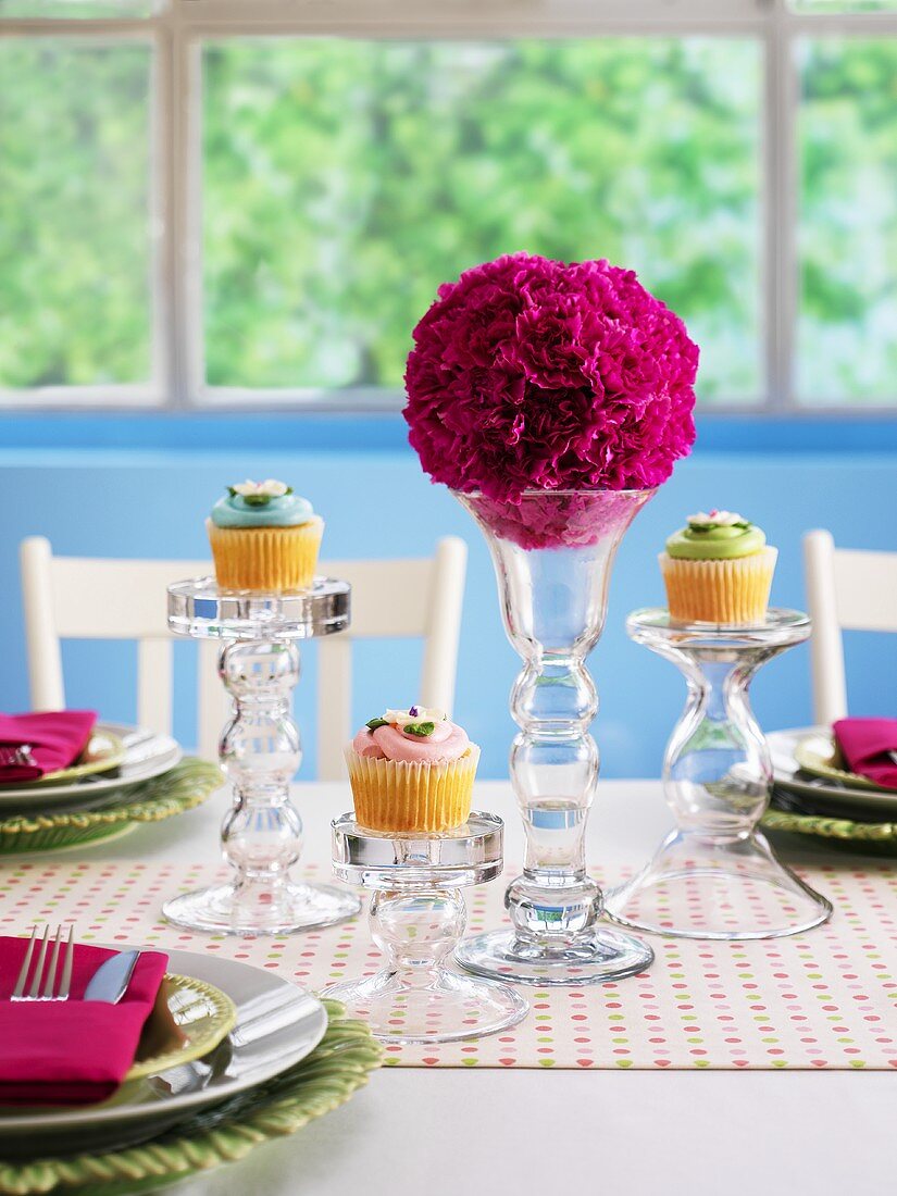 Festlich gedeckter Tisch mit Blumenkugeln Cupcakes