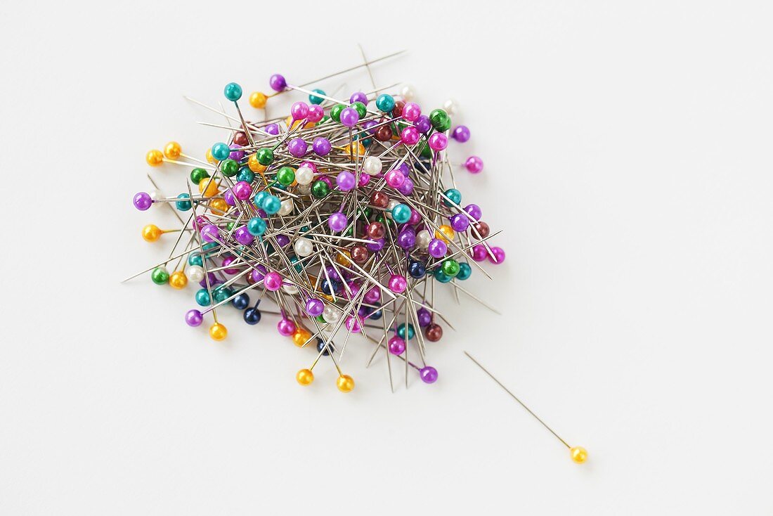 A pile (sewing) of pins of in front of a white background