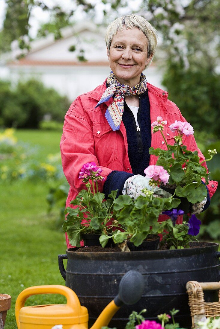 Woman planting up container in garden