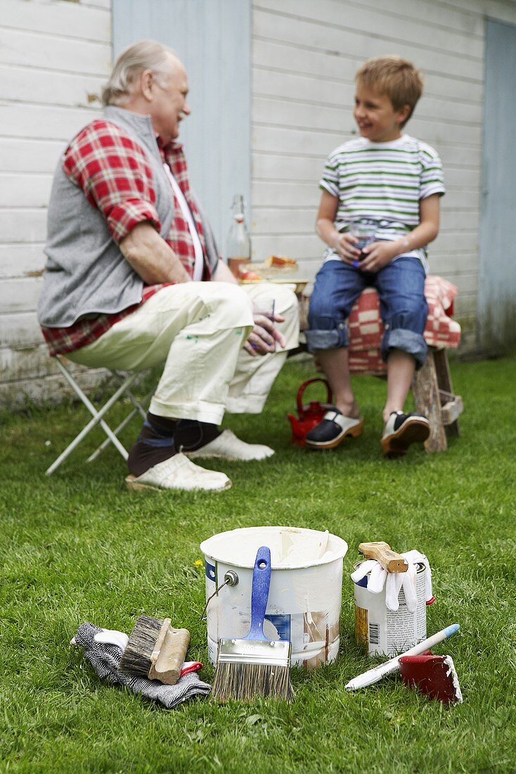 Grossvater und Enkel machen Pause im Garten