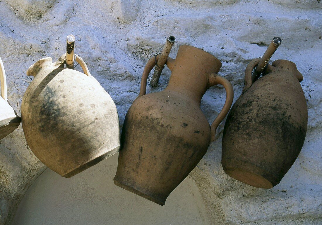 Mediterranean terracotta jugs on a stone wall