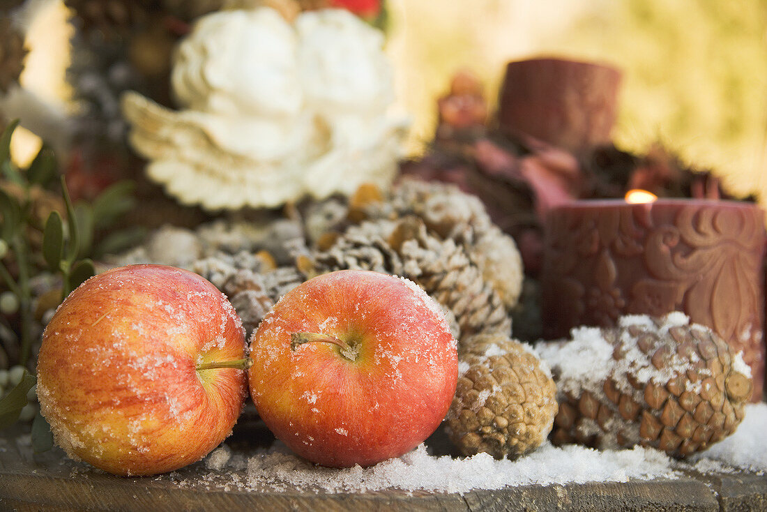 Weihnachtsdeko mit roten Äpfeln und Zapfen