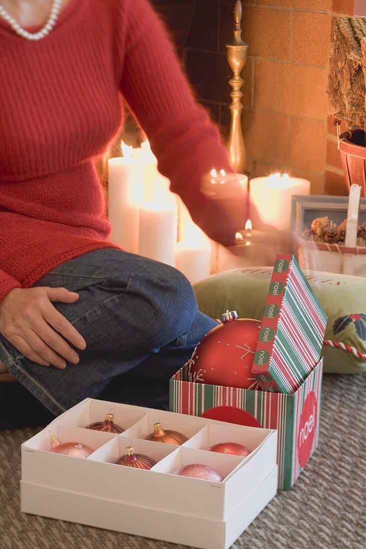 Frau öffnet Schachteln mit Weihnachtsschmuck