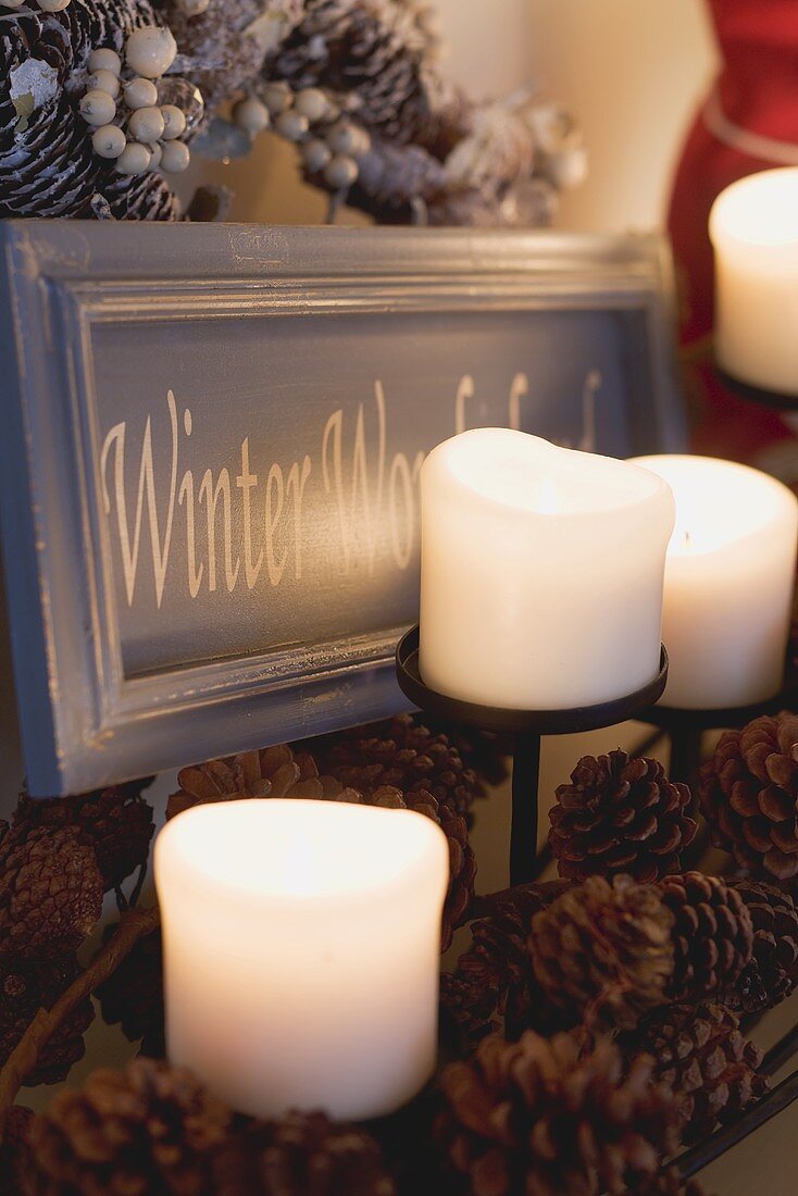 Candles, pine cones and festive sign