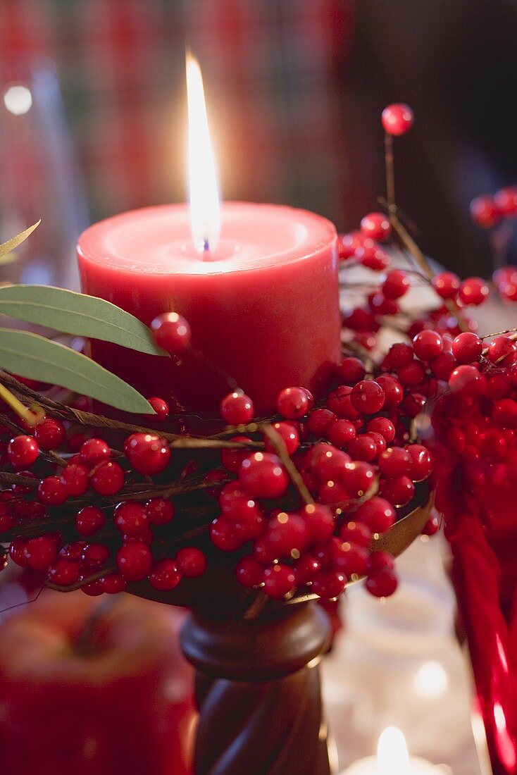 Red candle with berries