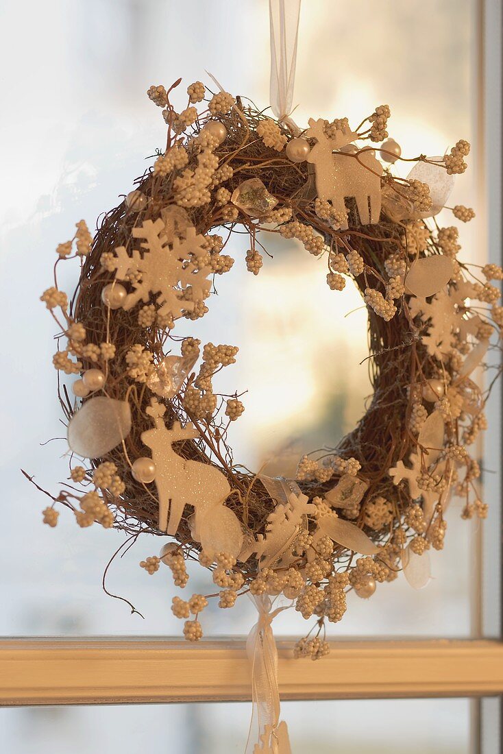 Christmas wreath with white reindeer at window