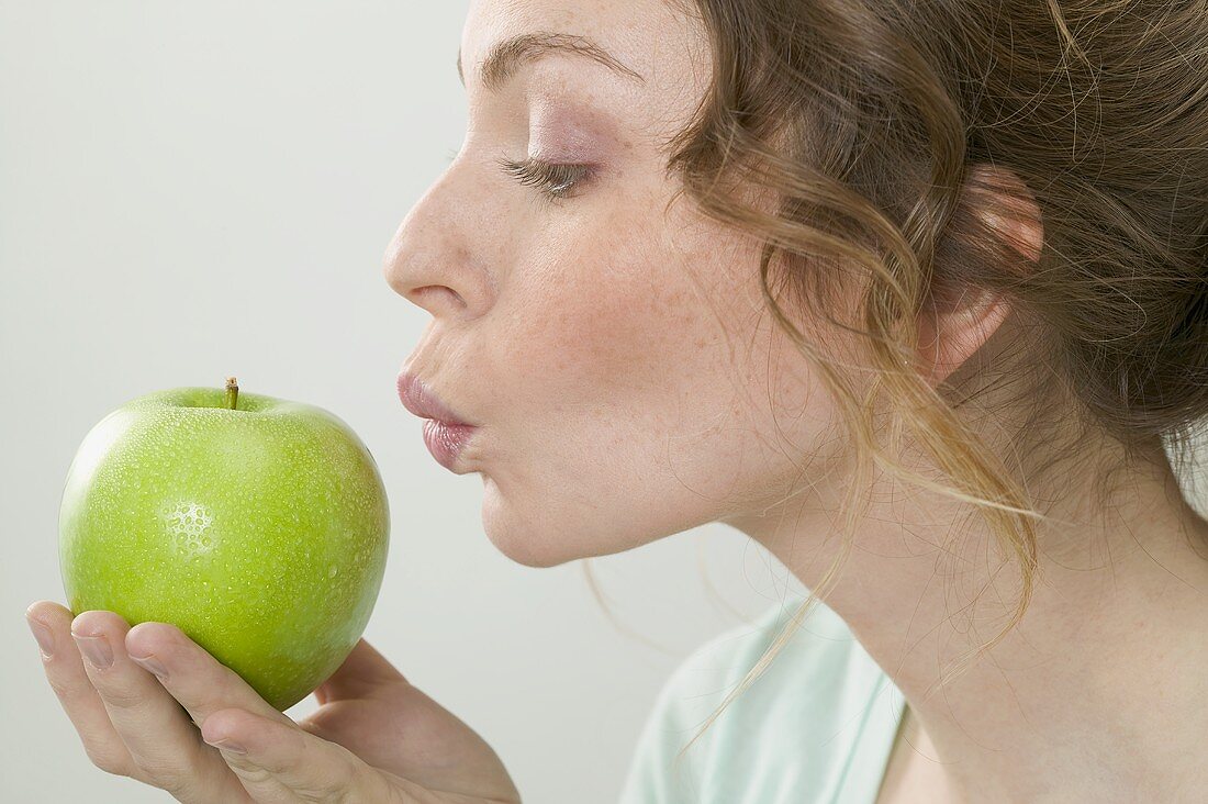 Frau hält grünen Apfel