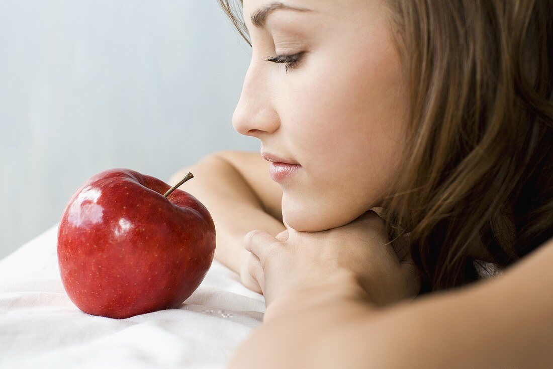 Junge Frau mit einem roten Apfel
