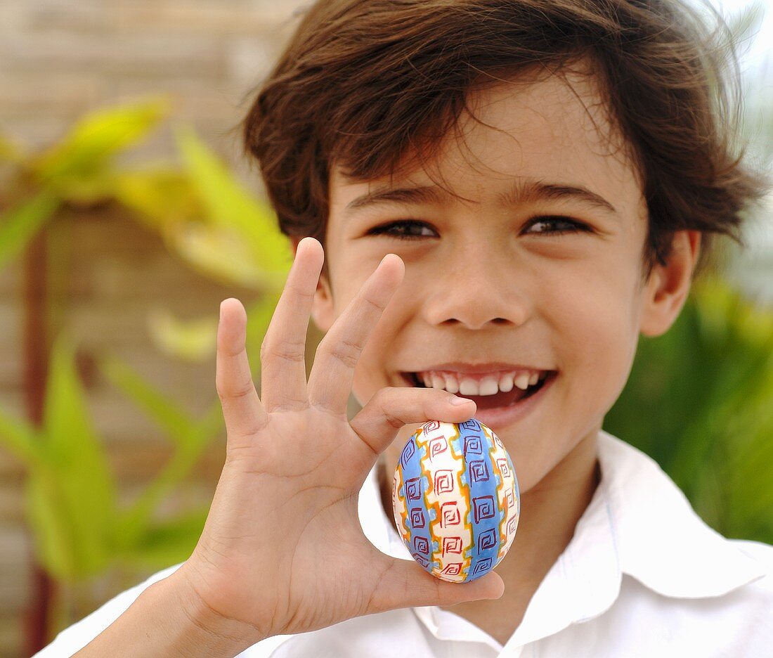 Junge hält ein Osterei in der Hand