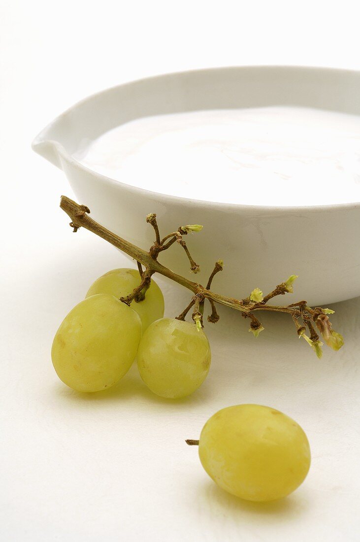 Skin cream in white dish with white grapes