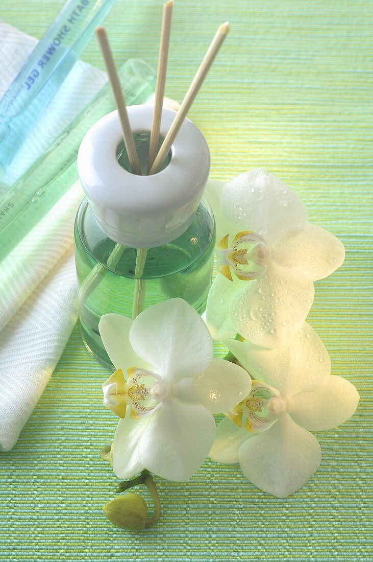 Duftlampe mit Aromastäbchen und Orchideenblüten