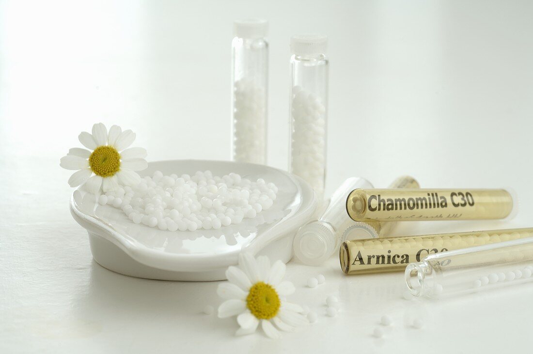 Globuli (homeopathic remedies) with chamomile flowers
