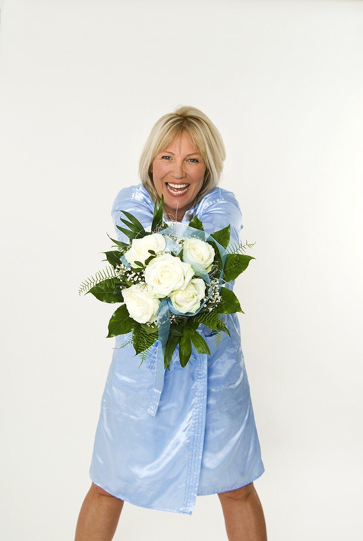 Smiling woman showing bouquet of white roses