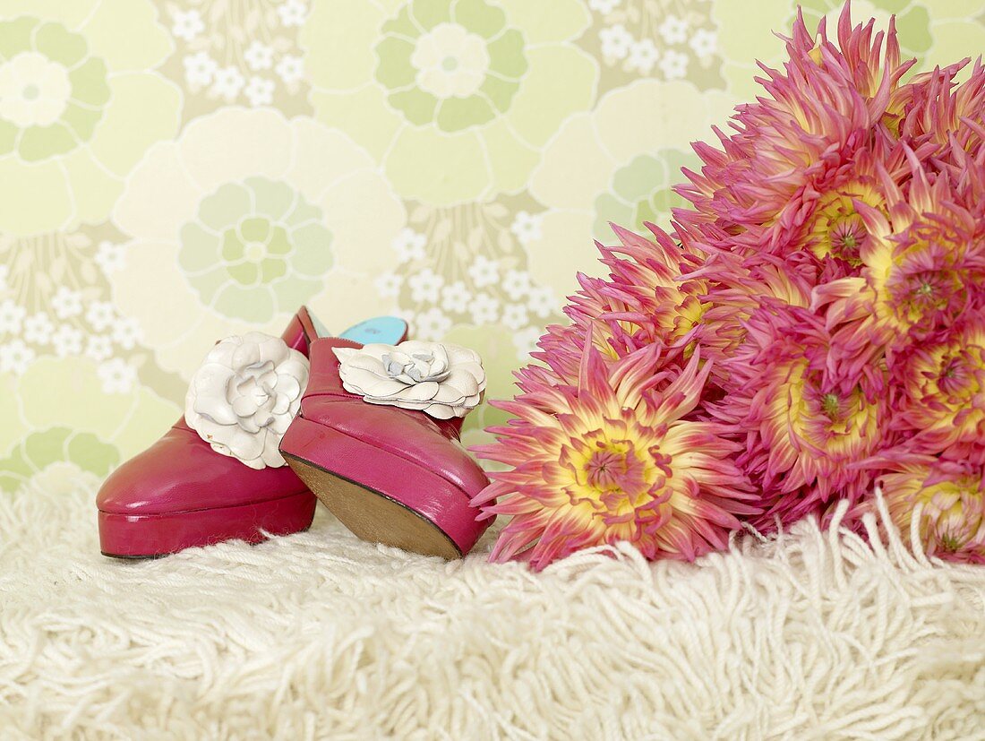 Schuhe mit Chrysanthemenstrauss auf Flokatiteppich