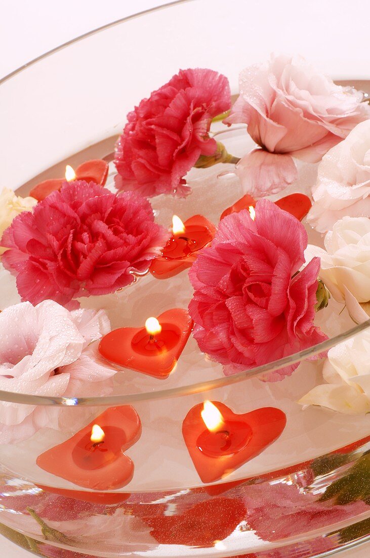 Floating candles and flowers in a glass bowl
