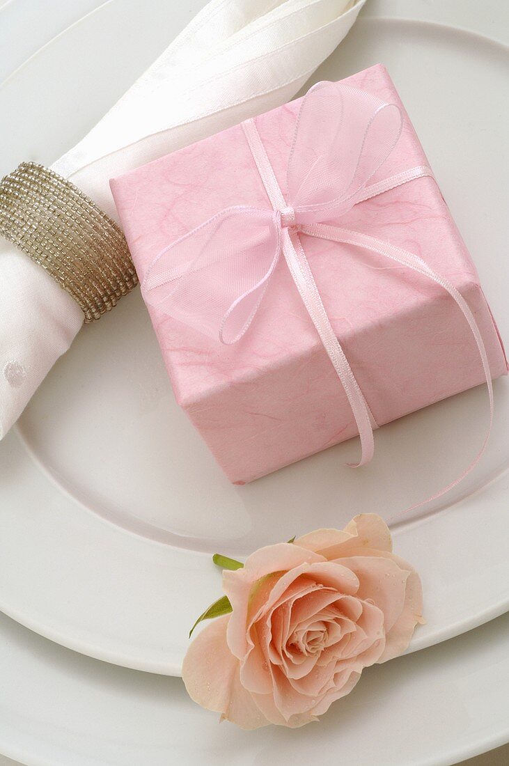 Tischgedeck mit rosafarbenen Geschenk