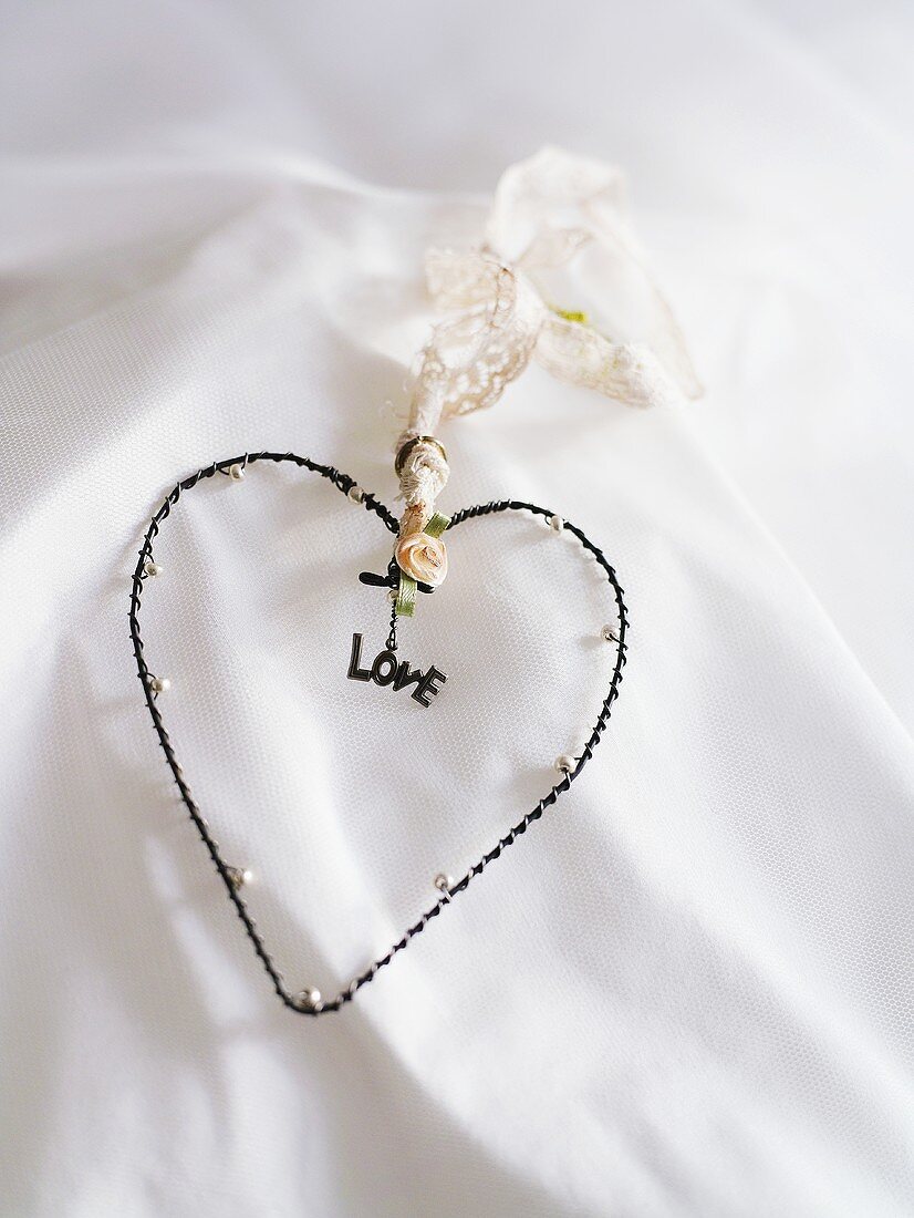 Herzform mit 'love' Schrift auf weißem Textil