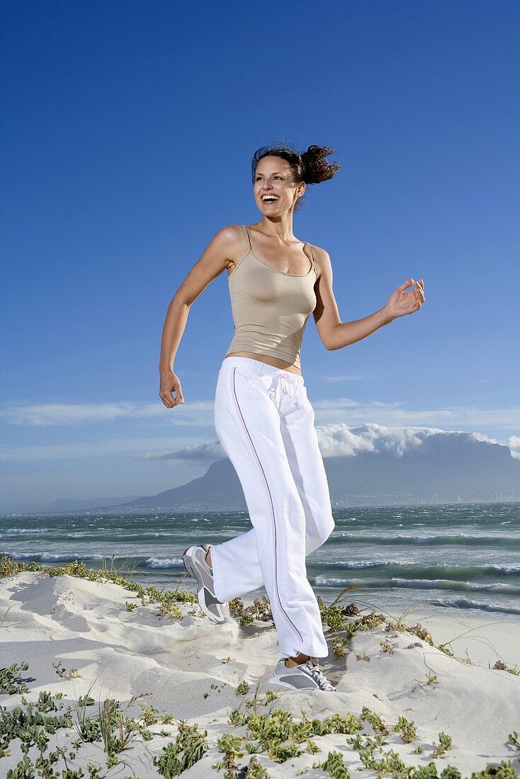 Frau joggt am Strand (Südafrika)