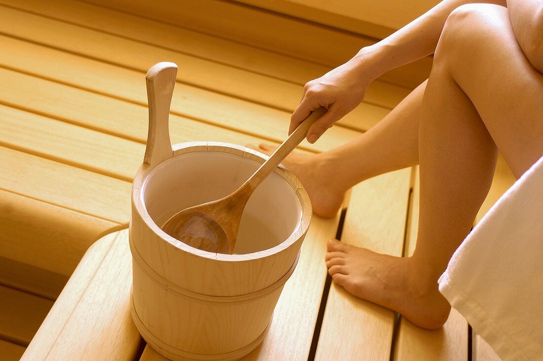 Woman with bucket in sauna