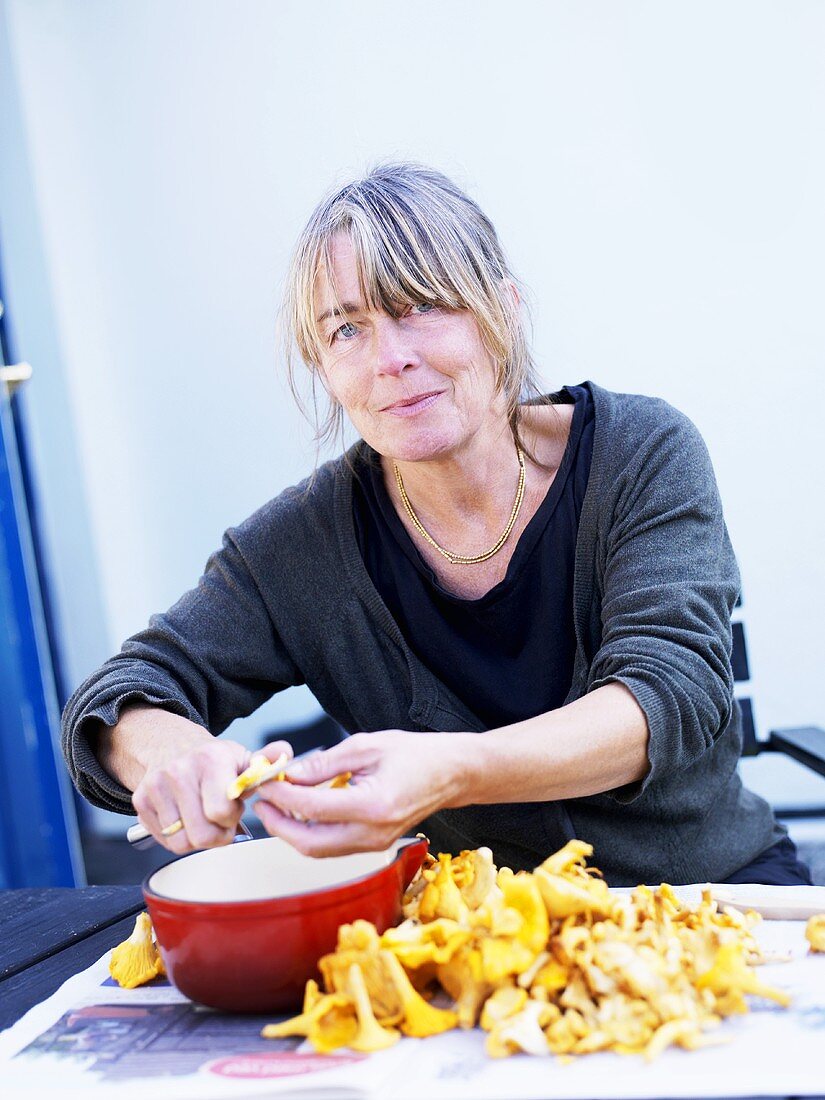 Woman cleaning chanterelles outside house