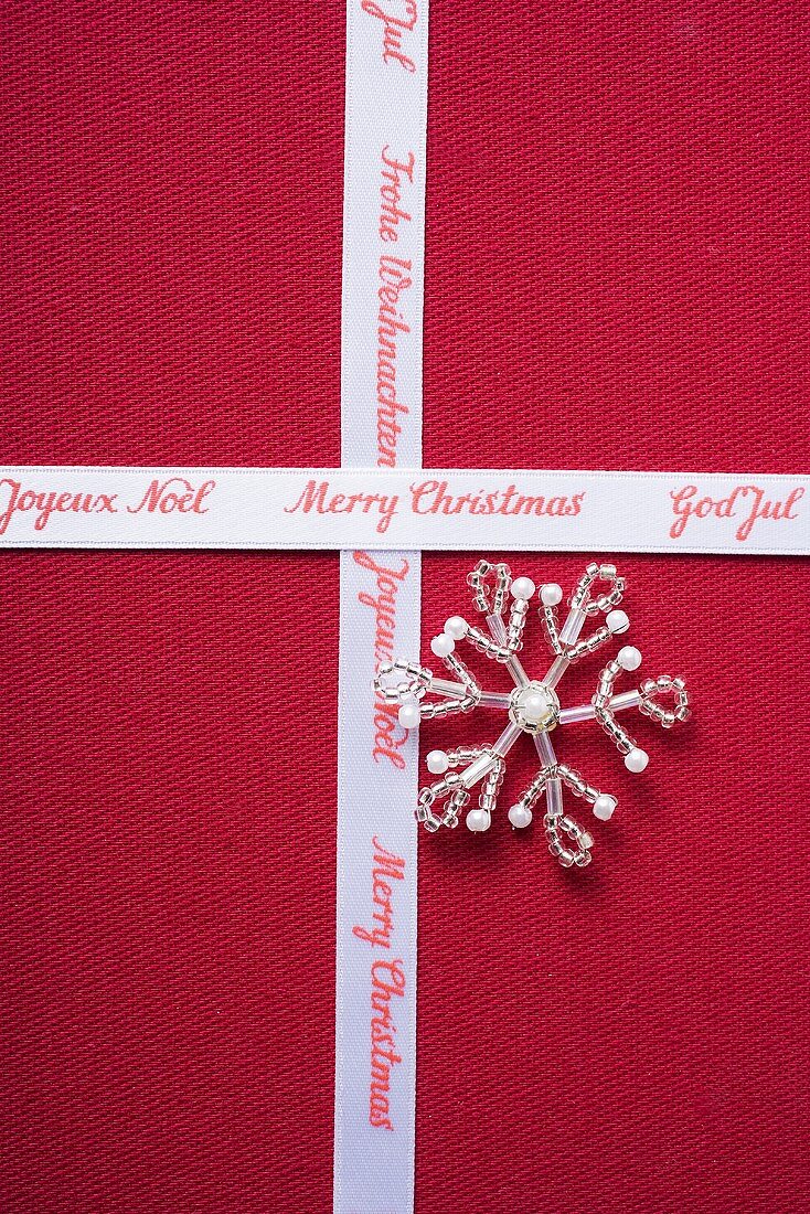 Christmas ribbon and silver star on red fabric