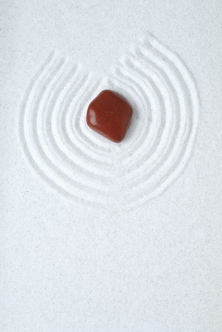 Healing stone on white sand