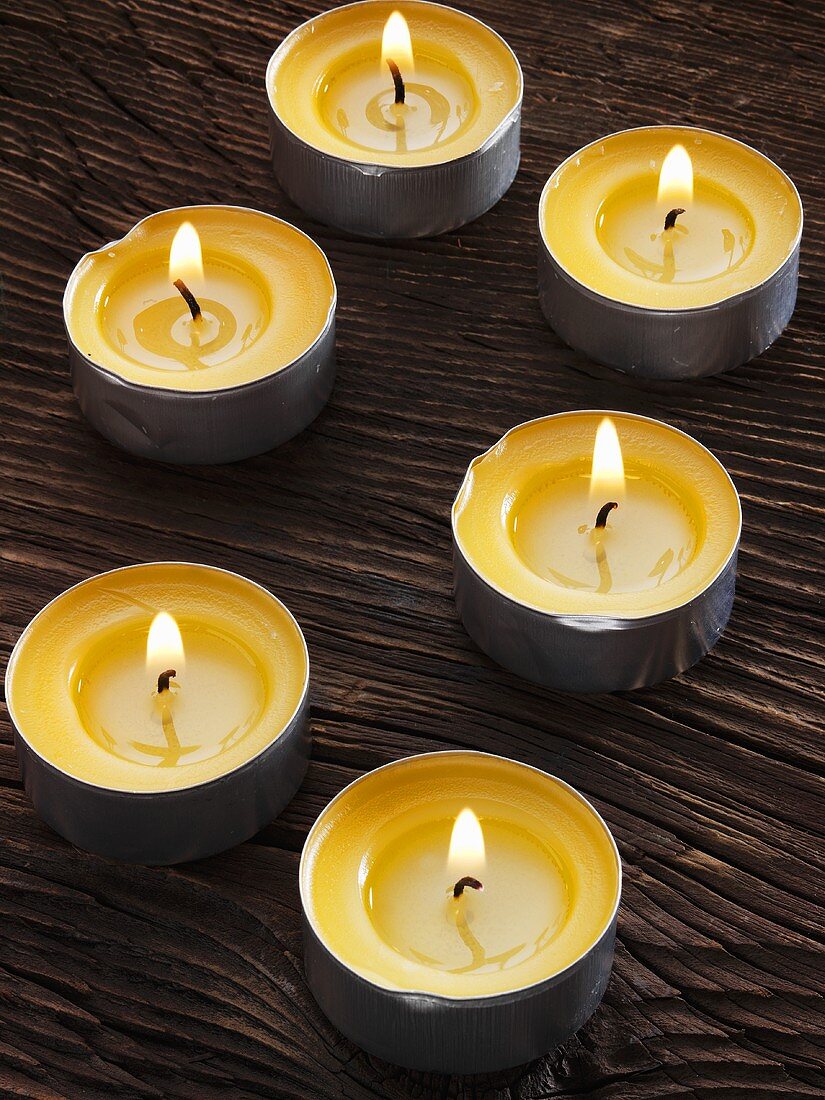 Several tealights on wooden background