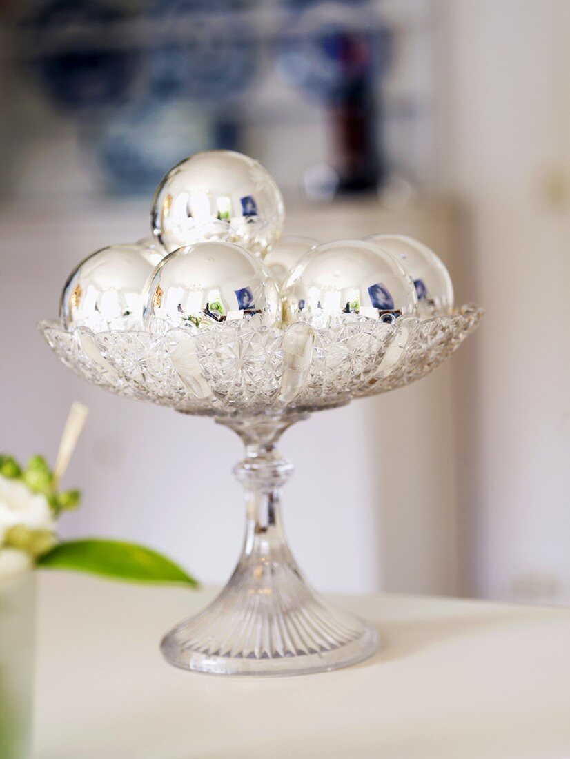 Christmas table decoration (silver baubles on glass stand)